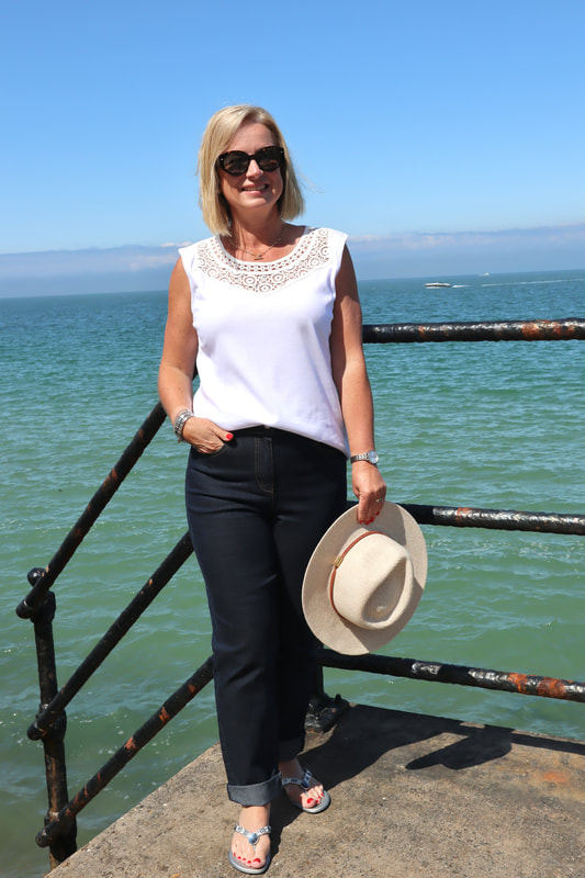 Woman in jeans and white t-shirt on beach Isle of wight | Summer styles for women over 50 | summer fashion | Afibel